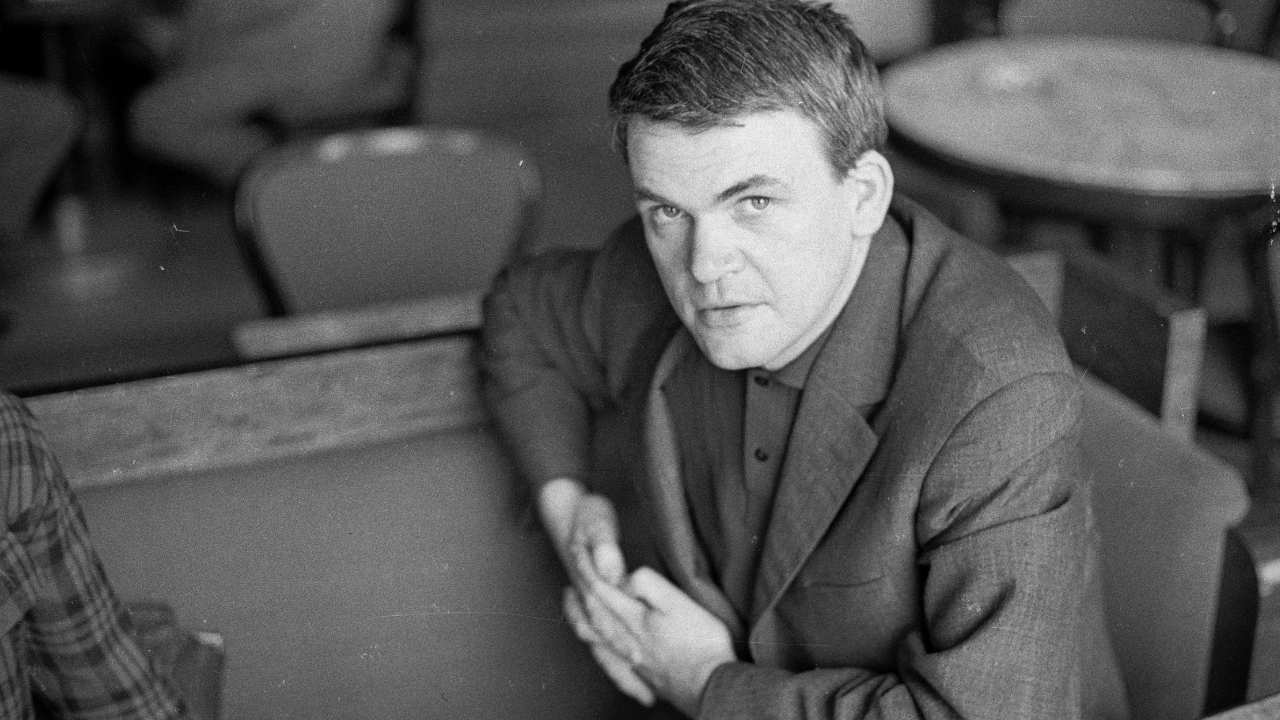 a man in a blazer looking up at the camera
